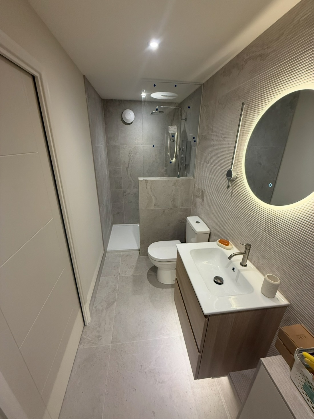 Fully tiled modern en-suite with walk-in shower and vanity unit