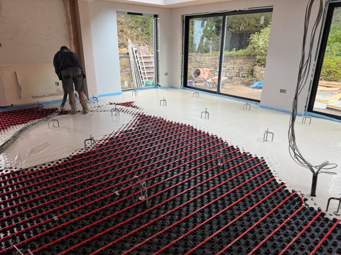 Large room with underfloor heating pipes laid ready for screed